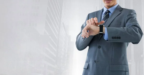 Empresario sosteniendo reloj con fondo brillante de la ciudad — Foto de Stock