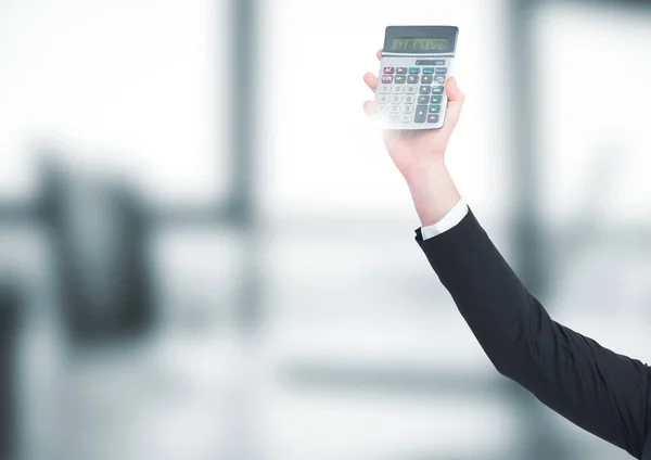 Ruka s kalkulačkou rozmazaný šedá úřad — Stock fotografie