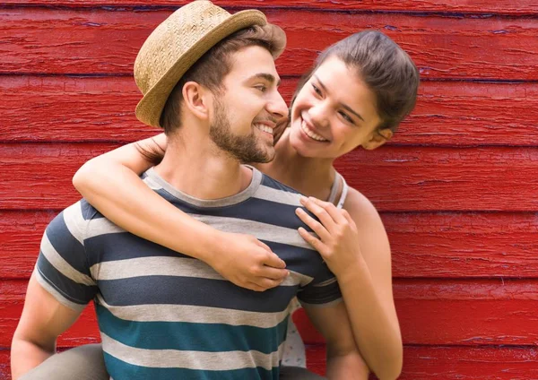 Young couple looking each other with red wood background — Stock Photo, Image