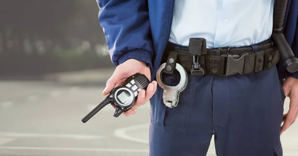 Ochroniarz dolnej części ciała z walkie talkie przeciwko rozmyte street — Zdjęcie stockowe