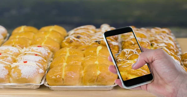 Beskurna hand tog bilden av dessert genom smarta telefonen vid bageri — Stockfoto