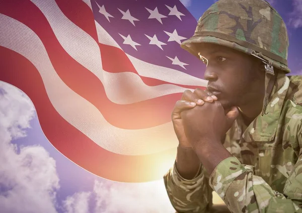 Солдат перед флагом США думает: — стоковое фото