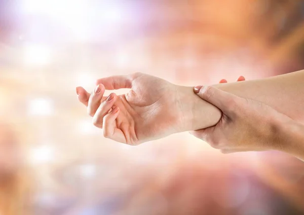 Hand restraining arm with sparkling light bokeh background — Stock Photo, Image