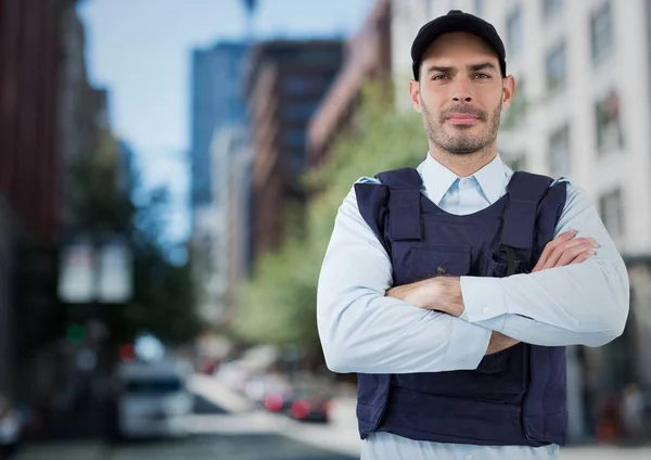 Security guard with arms folded against blurry street — Stock Photo, Image