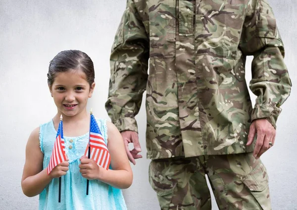Soldado e hija con banderas de EE.UU., en sala de hormigón — Foto de Stock