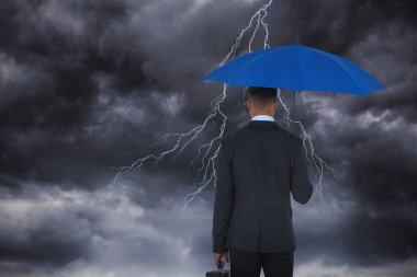 Mavi şemsiye ve evrak çantası taşıyan işadamı