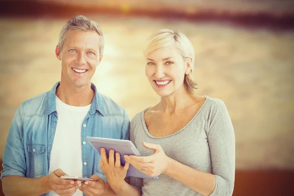 Casal com tablet digital e telefone celular — Fotografia de Stock