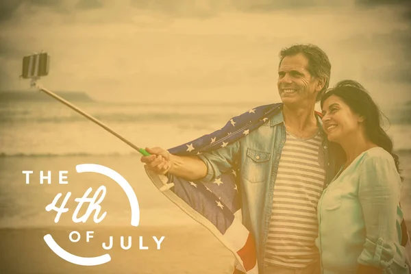 Paar houden van Amerikaanse vlag op het strand — Stockfoto