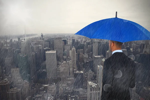 Podnikatel, drží modrý deštník a Aktovky — Stock fotografie