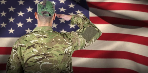 Στρατιώτης χαιρετισμό κατά την αμερικανική σημαία — Φωτογραφία Αρχείου