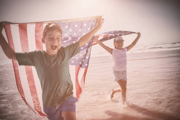 Kinderen nemen van Amerikaanse vlag op strand — Stockfoto