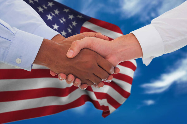 business people shaking hands against flag
