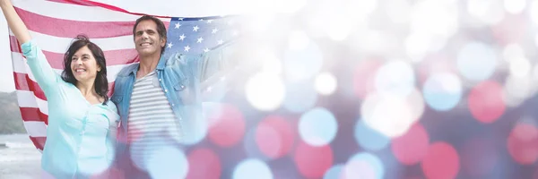 Paar houden van Amerikaanse vlag op het strand — Stockfoto