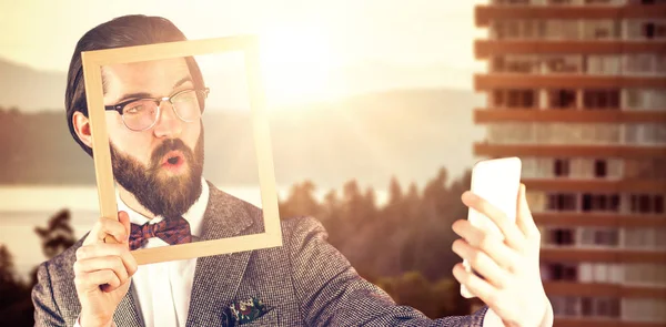 Hombre de negocios tomando selfie mientras sostiene marco —  Fotos de Stock