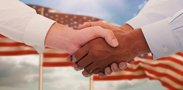 Händedruck gegen uns Flagge — Stockfoto