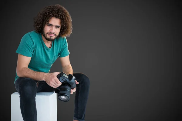 Fotografo maschio tenendo la fotocamera mentre seduto sul sedile — Foto Stock