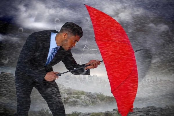 Podnikatel bránit s červeným deštníkem — Stock fotografie