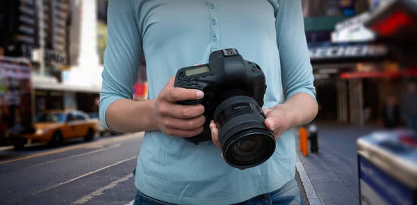 Composietbeeld van mid sectie van vrouwelijke fotograaf met digitale camera — Stockfoto