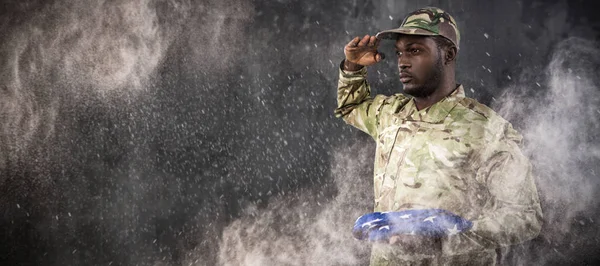 Soldado segurando bandeira americana e saudação — Fotografia de Stock