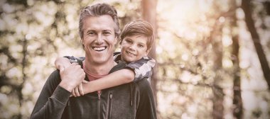 Mutlu baba oğul orman'da yürüyüş yaparken piggybacking