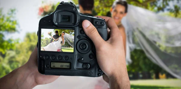 Složený obraz oříznutého obrazu ruce držící fotoaparát — Stock fotografie