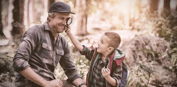 Jongen weergegeven: vergrootglas naar vader tijdens het wandelen in het bos — Stockfoto