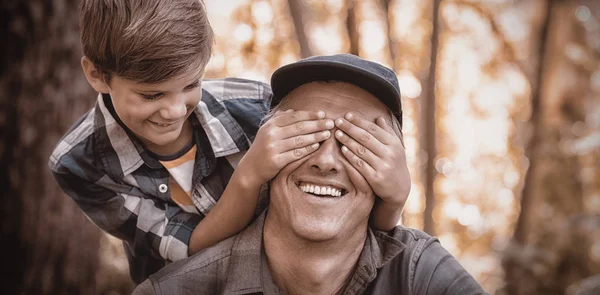 Pojke som täcker fäder ögon i skogen — Stockfoto