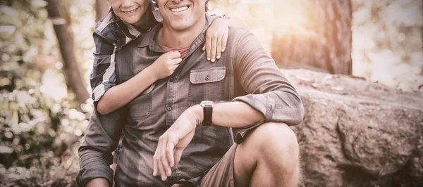 Sonriente padre e hijo caminando en el bosque —  Fotos de Stock