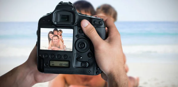 Mãos segurando câmera com grande família na tela — Fotografia de Stock