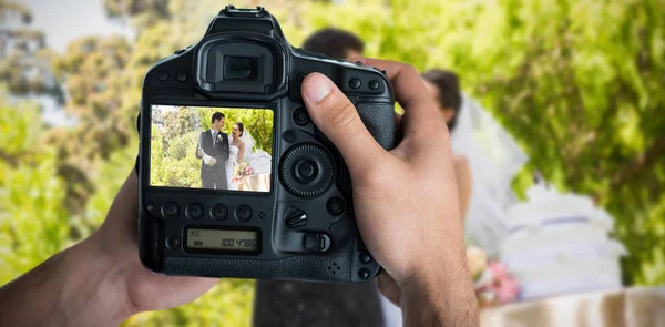 Immagine composita di immagine ritagliata di mani che tengono la macchina fotografica — Foto Stock