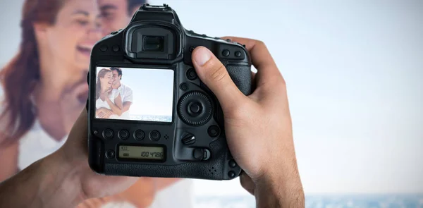 Fotógrafo segurando câmera com lindo casal na tela — Fotografia de Stock