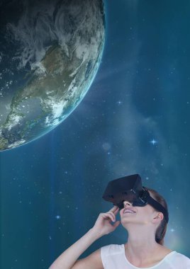 Kadın mavi gökyüzü karşı 3d bir gezegene ararken Vr kulaklık