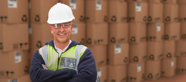 Composite image of worker wearing hard hat in warehouse — Stock Photo, Image