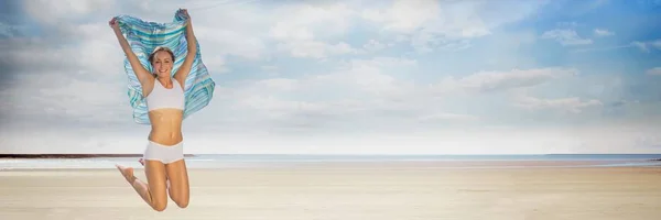 Женщина в нижнем белье с одеялом празднует на пляже — стоковое фото