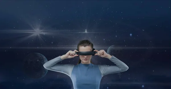 Nainen VR-kuulokkeissa katselemassa sinistä taivasta planeettojen ja soihdujen kanssa — kuvapankkivalokuva