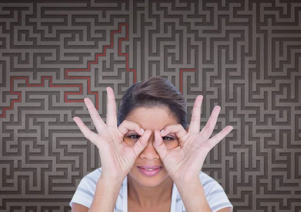 Mujer haciendo binoculares símbolos contra el fondo del laberinto 3d — Foto de Stock