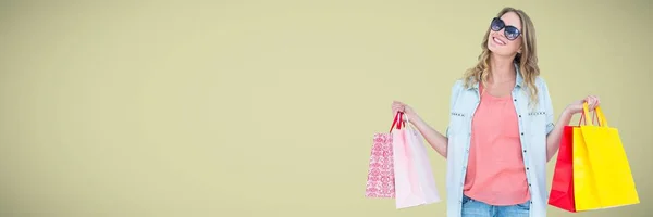 Shopper lächelt mit Taschen vor hellgrünem Hintergrund — Stockfoto