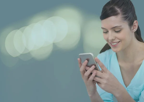 Donna sorridente sms con luci colorate — Foto Stock