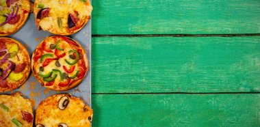 Yeşil Ahşap masanın üzerine düzenlenmiş pizza