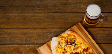 Taze bira cam pizzayla ahşap masaya servis