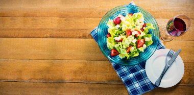 Ahşap masa üzerinde kırmızı şarap kase taze salata