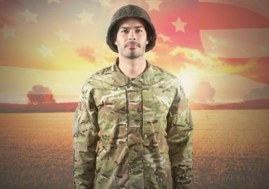 Gülümseyen asker Amerikan bayrağı üzerinde duran