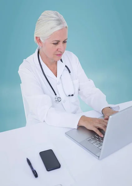 Doutor no laptop contra fundo azul — Fotografia de Stock