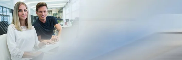 Mann und Frau am Laptop im Büro mit verschwommenem blau-grauen Übergang — Stockfoto