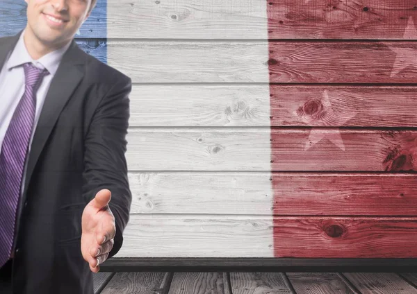 Деловой человек пожимает руки французскому флагу — стоковое фото