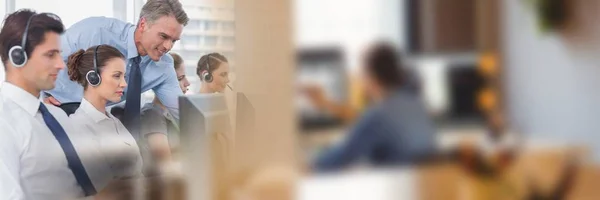 Call centre employees and blurry image of people at computer — Stock Photo, Image