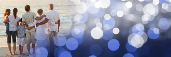 Achterkant familie op strand met blauwe bokeh overgang — Stockfoto