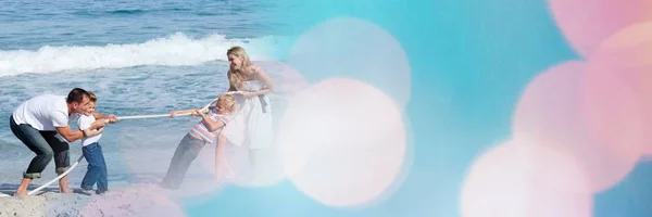 Familie op strand doet touwtrekken met blauwe en roze bokeh overgang — Stockfoto