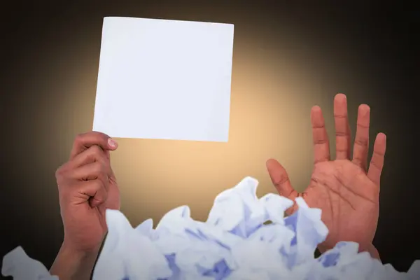 Image composite d'un tas de papier froissé avec une page blanche tenant la main — Photo