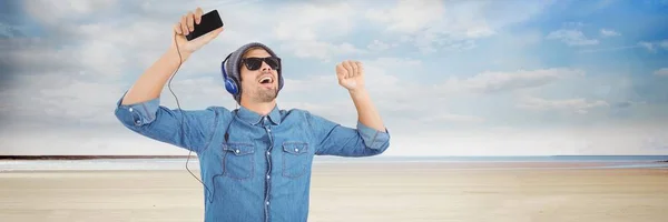 Duizendjarige man hoofdtelefoon dansen op strand — Stockfoto